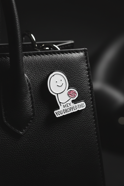 Enamel pin på svart läderväska